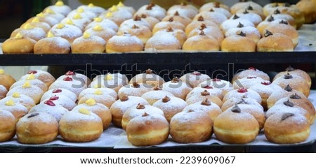 Fresh donuts with chocolate, jam at the bakery display for celebration. Sufganiyot - Israeli Donuts. Selective focus. Symbol of sweet Hanukkah donut - Sufganiyah. 