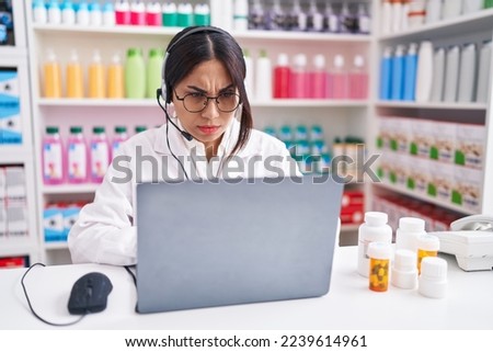 Young arab woman working at pharmacy drugstore using laptop skeptic and nervous, frowning upset because of problem. negative person.  Royalty-Free Stock Photo #2239614961