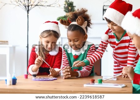 Little children in Christmas costumes with brushes and paints for Ebru at workshop