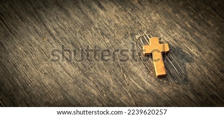 Christian cross on the wooden background.