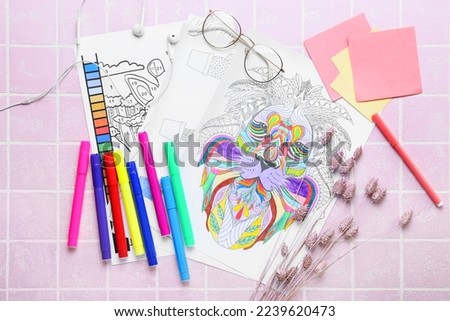 Coloring pages, felt-tip pens, dried flowers, sticky notes and eyeglasses on pink tile background