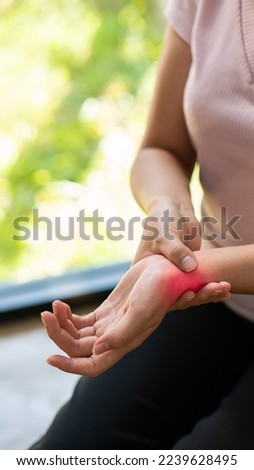 Woman having numbness wrist pain or Carpal Tunnel Syndrome holding her aching hand near young woman left wrist pain syndrome office health care concept vertical image