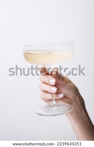 Hand holds glass goblet with champagne Royalty-Free Stock Photo #2239634251