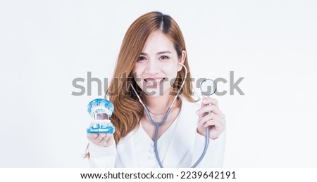 Beautiful Smart Asian Female medical expert standing with crossed arms in dental clinic office. Female doctor wearing white uniform,smiling and looking at camera.