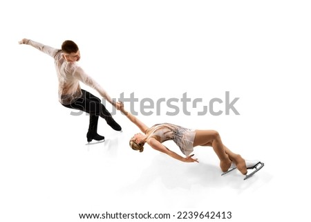 Death spiral. Portrait of young man and woman, figure skating athletes performing isolated over white studio background. Concept of movement, sport, beauty, hobby, competition, dance, choreography. Ad