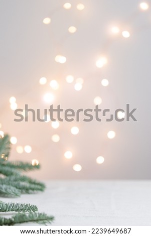 Christmas bokeh lights on the Xmas Background with fir brunches on a white background, Vertical New Year banner with empty space