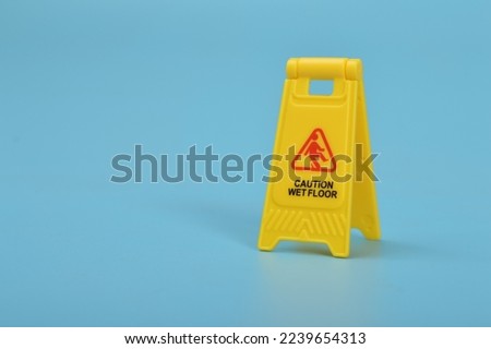 Caution wet floor sign isolated on a blue background. Copy space for the text.