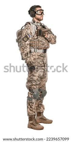 Soldier in Ukrainian military uniform, tactical goggles and headphones on white background