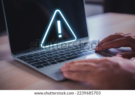 man hand on laptop with exclamation mark on virtual screen, online safety warning