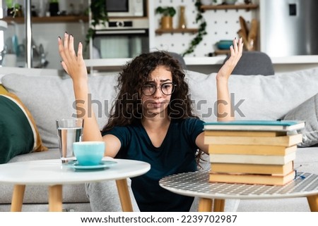 Young college woman law student frustrated with pile of books she need to read and study for exam. Future lawyer girl feeling anxious and nervous before exam. Education concept Royalty-Free Stock Photo #2239702987