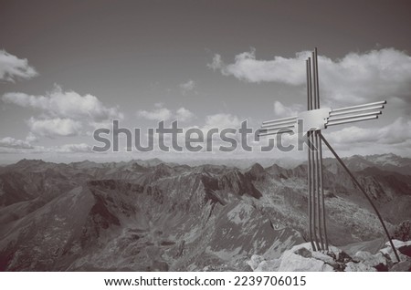 Mountains and cloudy sky. Cross on the top of Mount Masoni, Lombardy, Italy 