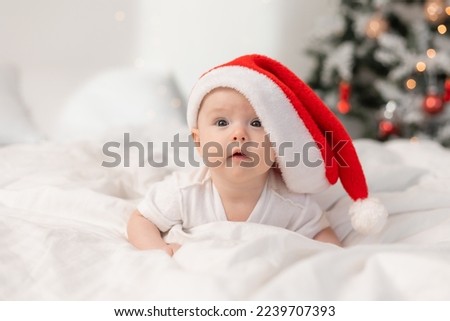 cute baby in Santa hat at home in bed. The first New Year. Christmas Gift. High quality photo