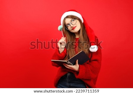 Christmas to-do list, a girl in a red Santa's hat is thinking about goals for the new year. Motivation for the future.