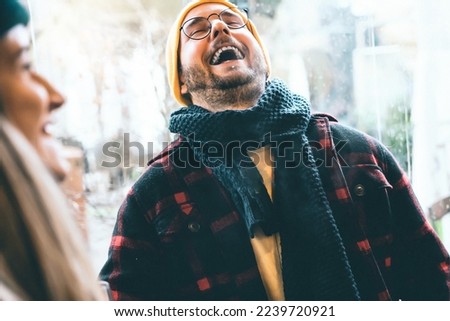 Young happy smiling guys wearing winter clothing having fun and laughing-portrait of couple sharing genuine time together at bar terrace on holiday- Love Lifestyle Bonding concept -Focus on eyeglasses Royalty-Free Stock Photo #2239720921