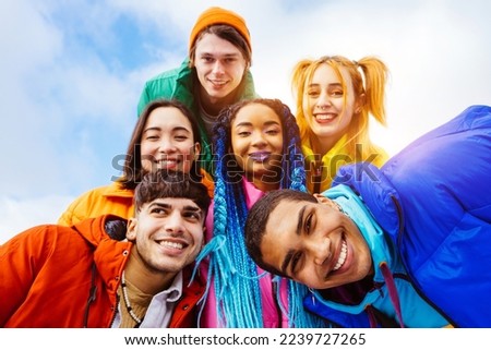 Multiracial group of young happy friends meeting outdoors in winter, wearing winter jackets and having fun - Multiethnic millennials bonding in a urban area, concepts about youth and lifestyle Royalty-Free Stock Photo #2239727265