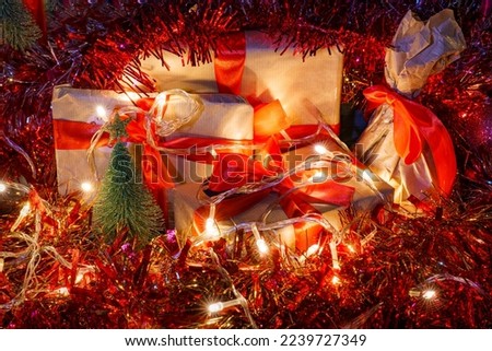 Composition with christmas gifts, electric garland and tinsel. Dark HDR christmas theme image