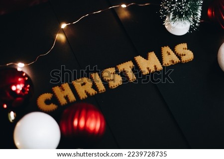 Gingerbread words Merry Christmas on old black table with Christmas decorations