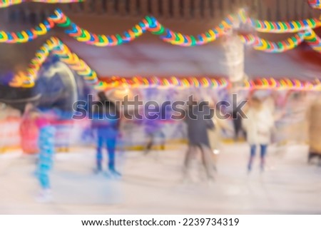 Blurred silhouettes of people on skating rink. Abstract background