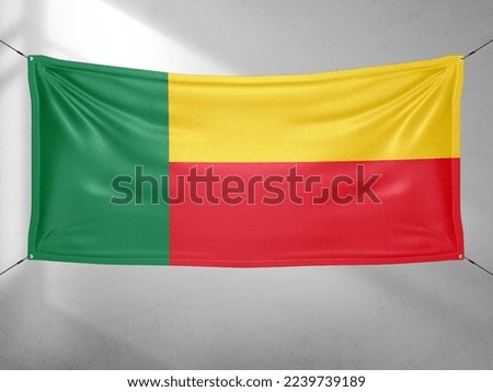 Benin national flag cloth fabric waving on beautiful grey sky.