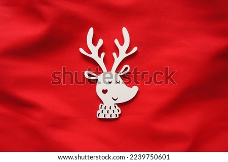 White figurine of cute cartoon deer on red backround. Christmas, Winter Season, Holidays Concept