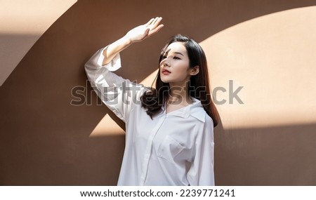 Portrait of young beautiful asian woman traveler hands protect face from sun light in fresh summer time. Happy cheerful asian girl in summer. Beauty sunscreen skin care make up model concept Royalty-Free Stock Photo #2239771241