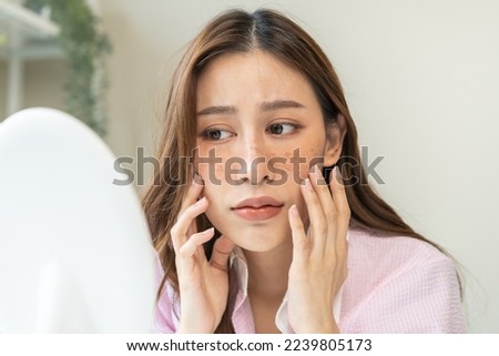 Dermatology, expression face worry asian young woman looking mirror hand touch facial at dark spot of melasma, freckles from pigment melanin, allergy sun. Beauty care, skin problem treatment, skincare Royalty-Free Stock Photo #2239805173