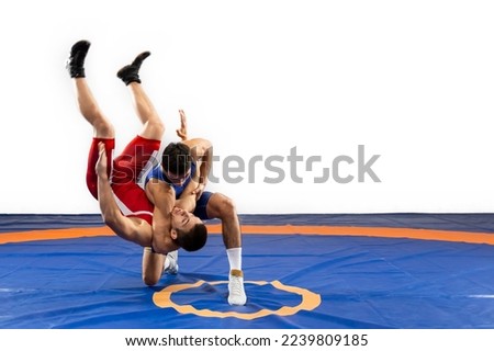 The concept of fair wrestling. Two greco-roman  wrestlers in red and blue uniform wrestling   on a wrestling carpet Royalty-Free Stock Photo #2239809185