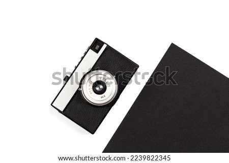 Old film camera on a black and white background, creative retro design, trendy vintage accessories, minimal flat lay.