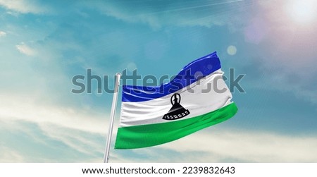 Lesotho Flag on pole for Independence day. The symbol of the state on wavy cotton fabric.