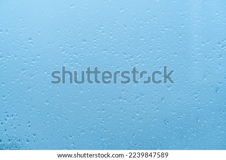 Water Drops Background. Rain drops on window on blue sky, blue background. drop of water on glass . blue background drops glass abstract texture