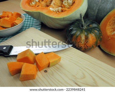          fresh zucchini in slices on a pumpkin cutting board. Autumn dinner preparation. Baked zucchini or zucchini                      