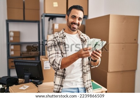 Young hispanic man ecommerce business worker counting dollars at office Royalty-Free Stock Photo #2239866509