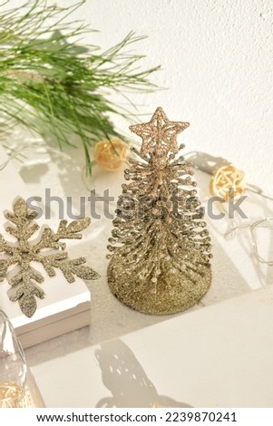 a small decorative Christmas tree on a white background among gift boxes