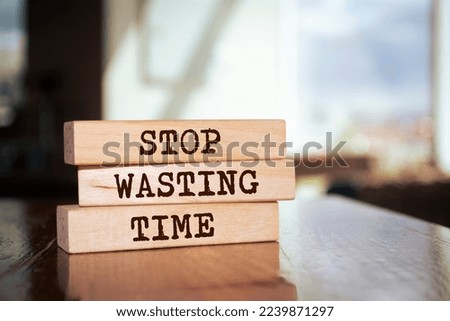 Wooden blocks with words 'Stop Wasting Time'.