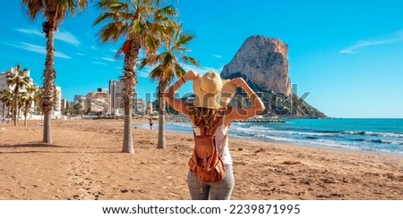Woman tourist on the tropical beach,  Calpe,  Alicante province in Spain, costa blanca Royalty-Free Stock Photo #2239871995