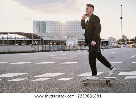 Man skating with skateboard while talking to the mobile
