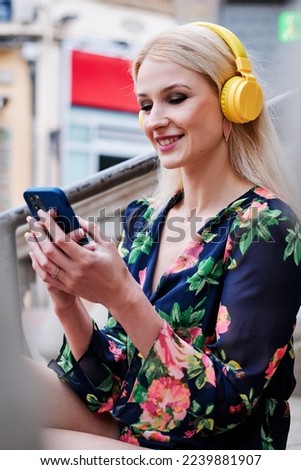 Blonde woman listening to music whit a mobile Royalty-Free Stock Photo #2239881907