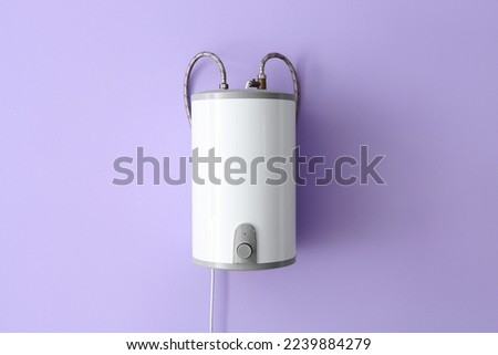 Modern electric boiler on lilac wall Royalty-Free Stock Photo #2239884279