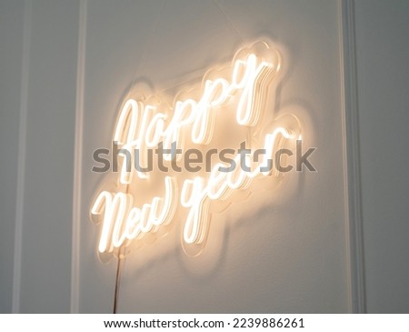 Christmas decor. A flexible neon sign with the words Happy New Year hanging on the wall at home