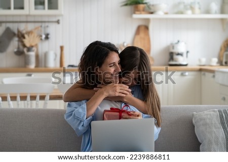 Little girl daughter hugging embracing happy beloved mother with love and tenderness while celebrating special occasion together at home, child wishing happy birthday to mom, greeting with Mothers Day Royalty-Free Stock Photo #2239886811