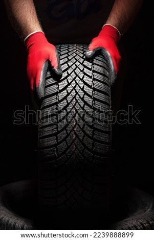 Car tire service and hands of mechanic holding new tyre on black background with copy space for text Royalty-Free Stock Photo #2239888899