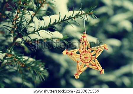 Christmas background with tree and natural old straw decoration. Winter holiday time with snow.