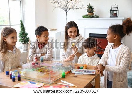 Little children with teacher during master class in Ebru painting on Christmas eve