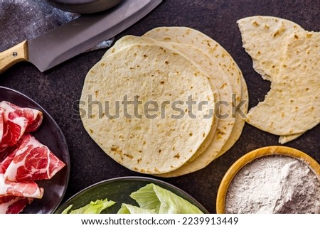 Mexican Corn Tortillas on the kitchen table. Top view. Royalty-Free Stock Photo #2239913449