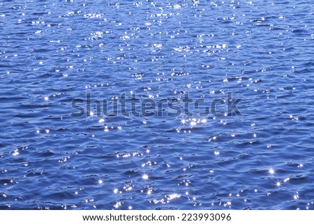 Sun rays reflected on a water surface in motion.