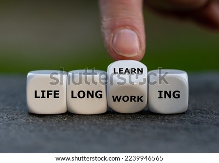 Hand turns dice and changes the expression 'life long working' to ' life long learning'. Royalty-Free Stock Photo #2239946565
