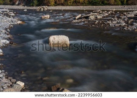 Water flowing over rocks, flowing through rocks. Long exposure time. A long exposition of the river in the Caucasus mountains. A long exposure on the river,