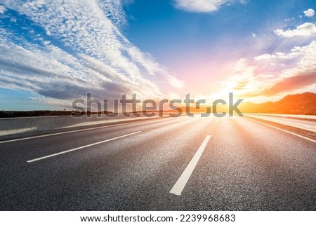 Empty asphalt road and mountain with colorful sky clouds at sunrise Royalty-Free Stock Photo #2239968683