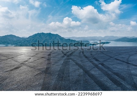 Asphalt road and mountains with lake natural scenery under the blue sky