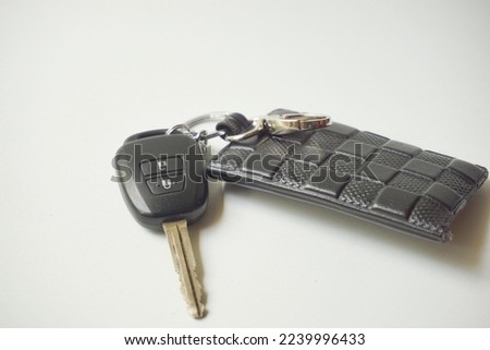 Modern car key with black wallet isolated on white, high angle view